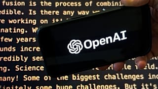 The OpenAI logo appears on a mobile phone in front of a screen showing part of the company website in this photo taken on Nov. 21, 2023 in New York.