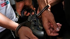A security guard removes handcuffs from inmates in Aragua state, 11 September, 2021