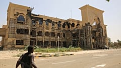 جندي من الجيش يمشي أمام القصر الجمهوري في الخرطوم ، السودان ، بعد أن استولى عليه الجيش السوداني ، 21 مارس / آذار 2025.