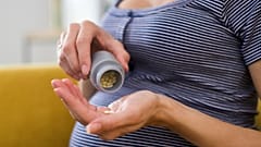 Eine schwangere Frau macht sich bereit, ein Medikament zu nehmen.