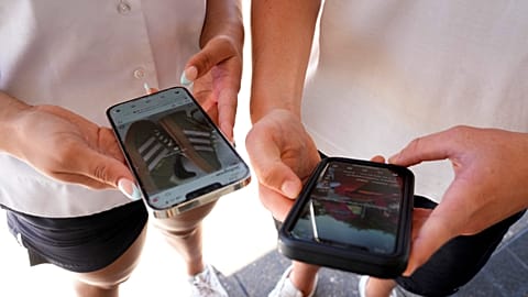 Two teenagers use their phones to view social media in Sydney, on Nov. 8, 2024.