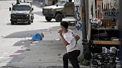 شبّان فلسطينيون يشتبكون مع قوات إسرائيلية عقب مداهمة نفذها الجيش في مدينة نابلس بالضفة الغربية، الأحد 4 مايو 2025.