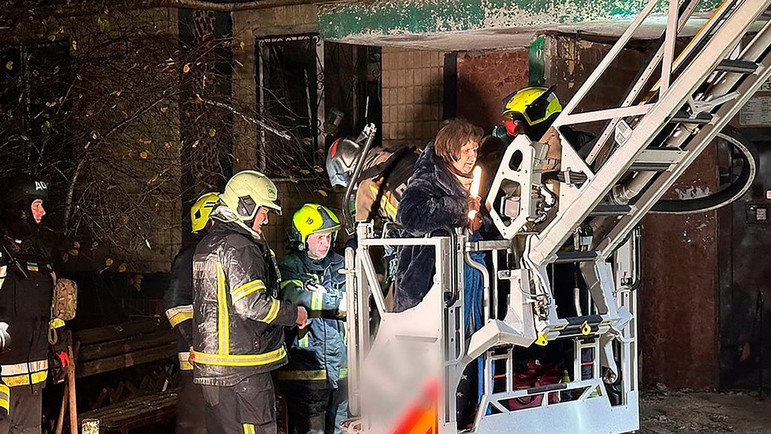 Firefighters evacuate a resident following a Russian rocket attack that hit a multi-storey apartment building in Dnipro, Ukraine, Saturday, Nov. 8, 2025