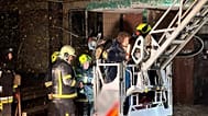 Firefighters evacuate a resident following a Russian rocket attack that hit a multi-storey apartment building in Dnipro, Ukraine, Saturday, Nov. 8, 2025