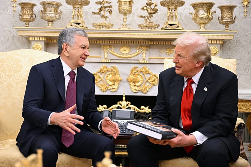 El presidente de Uzbekistán, Shavkat Mirziyoyev, entrega un libro a Donald Trump durante su encuentro en el Despacho Oval de la Casa Blanca, Washington, jueves 6 de noviembre de 2025.