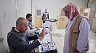 A displaced Yazidi man has his fingerprint verified before voting ahead of Iraq's parliamentary elections, set for Nov. 11, at a polling station in the Sharia camp near Dohuk