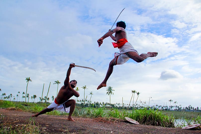 Two men engage in a traditional Kalaripayattu duel in Kottayam, Kerala.