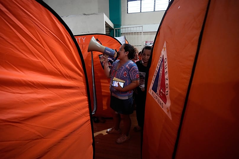 Un trabajador utiliza un megáfono para llamar a los residentes de un centro de evacuación mientras el tifón Fung-wong entra en el país el domingo 9 de noviembre de 2025.