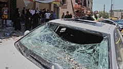 تجمع الناس بجانب سيارة تضررت في غارة جوية إسرائيلية في بلدة النبطية، جنوب لبنان، يوم الجمعة، 27 يونيو 2025.