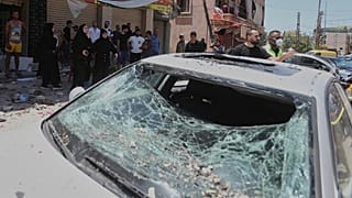 تجمع الناس بجانب سيارة تضررت في غارة جوية إسرائيلية في بلدة النبطية، جنوب لبنان، يوم الجمعة، 27 يونيو 2025.