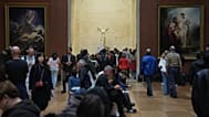 The marble hellenic sculpture The Winged Victory of Samothrace, center, is pictured as people visit the Louvre museum three days after historic jewels were stolen.