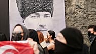 طلاب جامعيون يسيرون أمام صورة لمؤسس تركيا مصطفى كمال أتاتورك في إسطنبول، تركيا، الخميس 27 مارس/آذار 2025