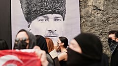 طلاب جامعيون يسيرون أمام صورة لمؤسس تركيا مصطفى كمال أتاتورك في إسطنبول، تركيا، الخميس 27 مارس/آذار 2025