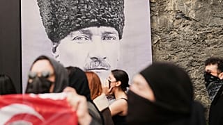 طلاب جامعيون يسيرون أمام صورة لمؤسس تركيا مصطفى كمال أتاتورك في إسطنبول، تركيا، الخميس 27 مارس/آذار 2025