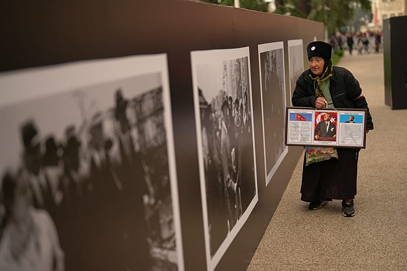 سيدة تحمل صورة مصطفى أتاتورك في قصر دولما بهجة في إسطنبول، تركيا، يوم الاثنين 10 نوفمبر 2025