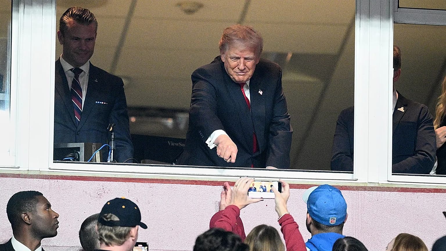 En un partido reciente de fútbol americano, Pete Hegseth (izquierda) observa al público detrás de su presidente, Donald Trump, el 9 de noviembre en Landover, Maryland 