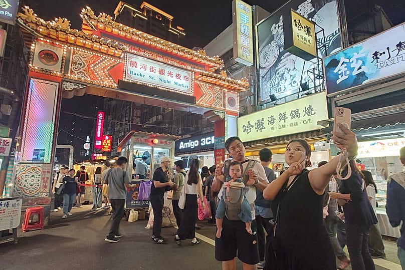People visit the Raohe night market in Taipei, 30 October, 2025