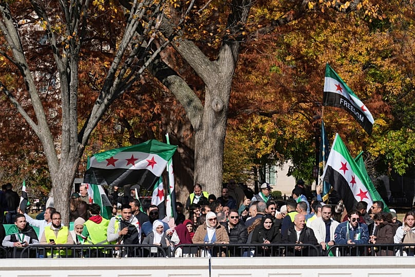 People with Syrian flags rally outside of the White House, Monday, Nov. 10, 2025, in Washington, following Syria's President al-Sharaa's meeting with President Donald Trump.