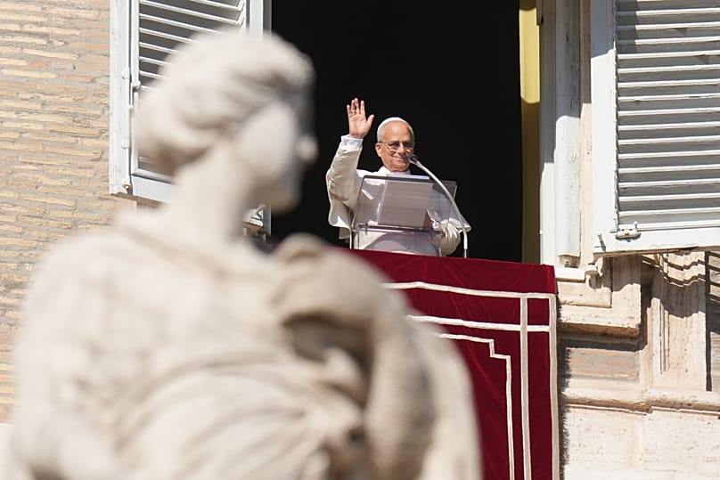 Pope Leo XIV waves during the Angelus noon prayer from the window of his studio at the Vatican, 9 November, 2025