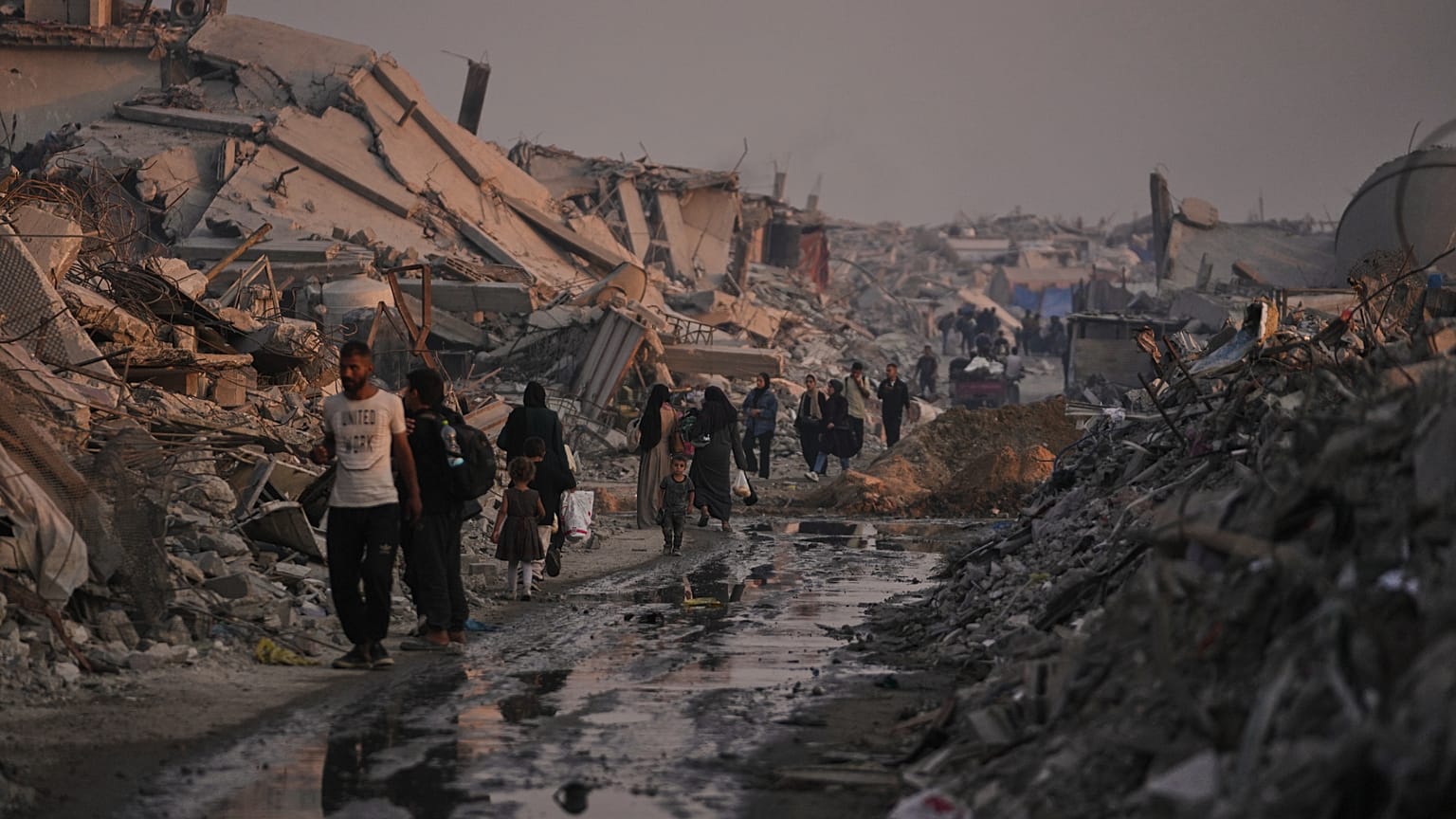 فلسطينيون في قطاع غزة يمشون بين الركام