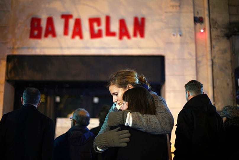 FILE - In this Nov. 13, 2016 file photo, women hug in front of the Bataclan concert hall in Paris, as France marked the anniversary of Islamic extremists' coordinated attacks 