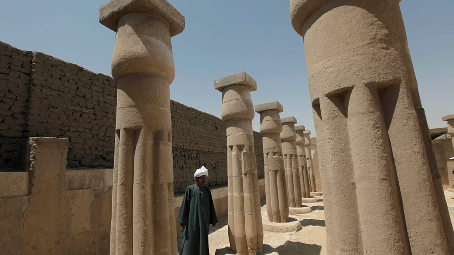 عامل من هيئة آثار مصر يقف في موقع مقبرة الدولة الحديثة