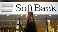 FILE - A woman walks in front of SoftBank store in Ginza shopping district in Tokyo, Jan. 20, 2020. (AP Photo/Eugene Hoshiko, File)
