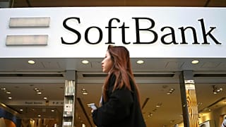 FILE - A woman walks in front of SoftBank store in Ginza shopping district in Tokyo, Jan. 20, 2020. (AP Photo/Eugene Hoshiko, File)