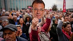 امرأة تحمل قناعًا يحمل وجه رئيس بلدية إسطنبول المعارض المسجون أكرم إمام أوغلو بمحيط محكمة تشاجلايان في إسطنبول، تركيا، الأحد 26 أكتوبر/تشرين الأول 2025.