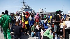 Μετανάστες ετοιμάζονται να επιβιβαστούν σε πλοίο του ιταλικού ναυτικού για να απομακρυνθούν από τη νήσο Λαμπεντούζα μετά τη διάσωσή τους στη θάλασσα