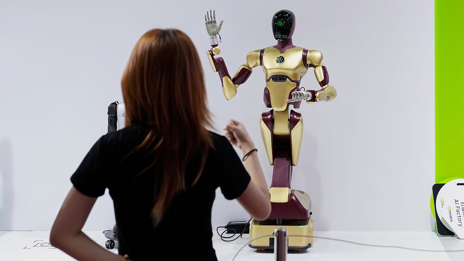 An exhibitor gives command to a robot at Nvidia's booth during a conference in Beijing, China, on July 18, 2025.