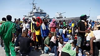 Migranten bereiten sich darauf vor, an Bord eines Schiffes der italienischen Marine zu gehen