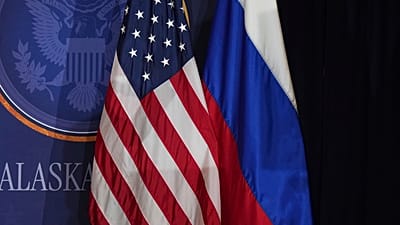  تظهر في الصورة الأعلام الأمريكية والروسية على المسرح في قاعدة إلمندورف ريتشاردسون المشتركة في ألاسكا، يوم الجمعة 15 أغسطس/آب 2025.
