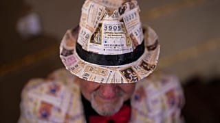 Uno spettatore attende l'inizio dell'estrazione annuale della lotteria di Natale, nota come "El Gordo", al Teatro Real di Madrid, Spagna, 22 dicembre 2024