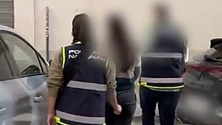 Dos agentes de la Policía Nacional escoltan a una ciudadana chilena detenida por sus presuntos vínculos con el Tren de Aragua, en Murcia, el 12 de noviembre de 2025.