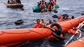 صورة تعبيرية  لمهاجرين سقطوا في الماء يكافحون للتشبث بعوامة قبل أن ينقذهم رجال إنقاذ، على بعد حوالي 35 ميلاً من ليبيا، في البحر الأبيض المتوسط