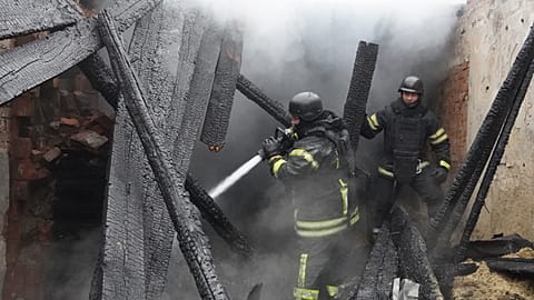Des secouristes éteignent un incendie dans un bâtiment endommagé par une frappe russe à Kharkiv, en Ukraine.