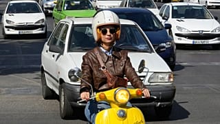 Merat Behnam drives her motorbike in downtown Tehran