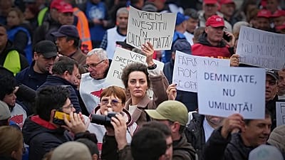 A woman holds a banner that reads "We want investments in the railway network" at a protest in Bucharest, 12 November, 2025