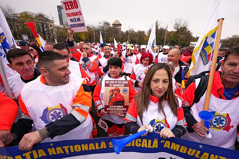 A woman holds a banner that reads "Don't hit the ones who save you" as trade union members protest against austerity measures in Bucharest, 12 November, 2025