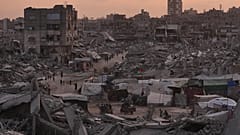 فلسطينيون يسيرون بين أنقاض حي الشيخ رضوان في غزة بعد الهجمات الجوية والبرية الإسرائيلية، 11 نوفمبر 2025.