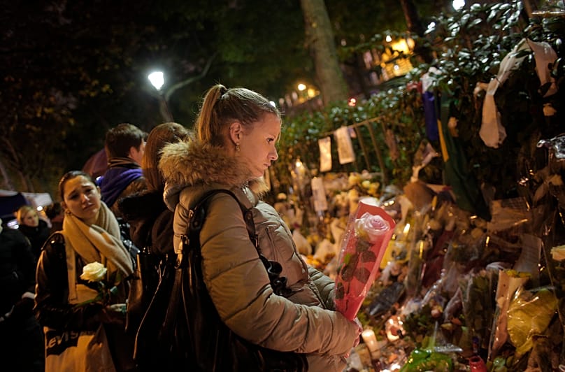 A woman pays respect to the victims, outside the Bataclan concert hall, which was a site of last Friday's attacks, in Paris, Nov. 17, 2015. 