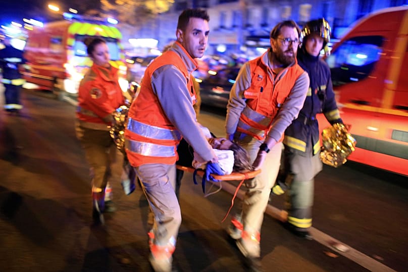 Medics evacuate a woman from the Bataclan concert hall after a shooting in Paris Nov. 13, 2015.
