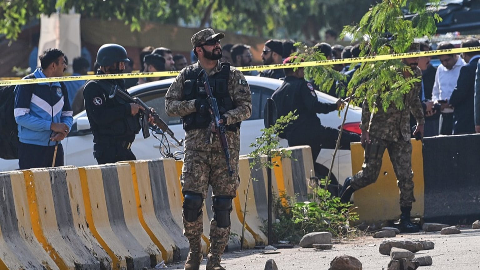 جنود من الجيش وعناصر من الشرطة يقفون قرب سيارة متضررة في إسلام آباد، الثلاثاء 11 نوفمبر 2025.