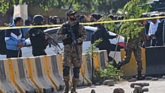 جنود من الجيش وعناصر من الشرطة يقفون قرب سيارة متضررة في إسلام آباد، الثلاثاء 11 نوفمبر 2025.