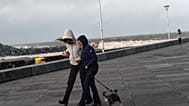 Mujeres pasean con un perro bajo un fuerte viento en la ciudad de San Sebastián, norte de España, el martes 17 de enero de 2023.