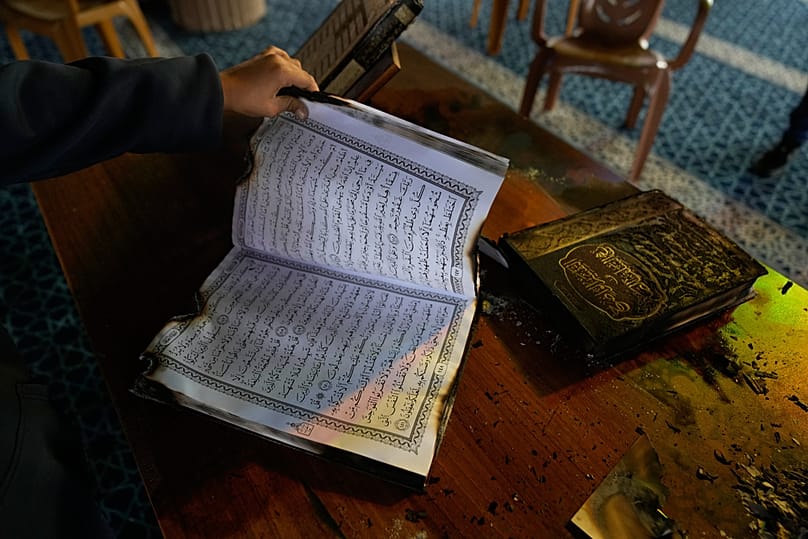 طفل يتفقد نسخًا محترقة من القرآن داخل مسجد أضرم مستوطنون إسرائيليون النار فيه بالضفة الغربية، الخميس 13 نوفمبر 2025.