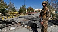 A soldier stands guard next to the main gate of an army-run cadet college that was assaulted by militants in Wana, 13 November, 2025