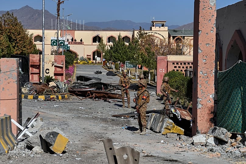 Soldiers stand guard next to the main gate of an army-run cadet college that was assaulted by militants in Wana, 13 November, 2025