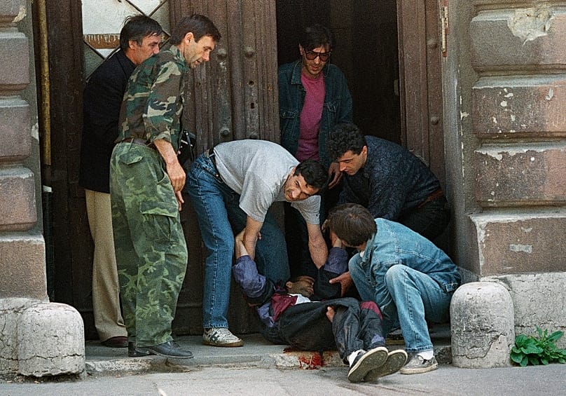 Egy orvlövész által eltalált vérző férfit vonszoltak be egy kapualj biztonságába, 1995. június 14-én